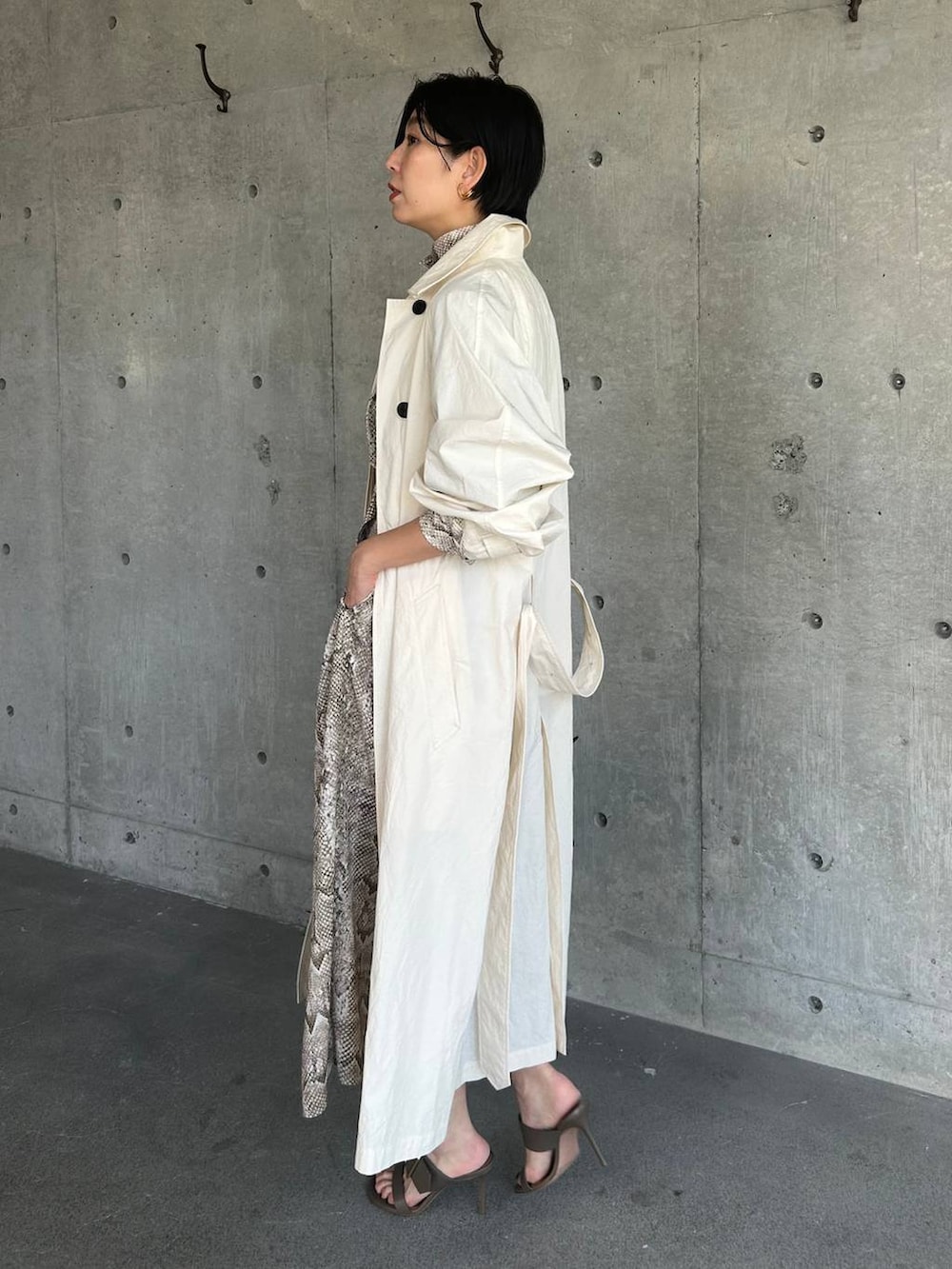 ホワイト系のステンカラーコート、ベージュ系のワンピースを着用したレディースの春コーディネートの6枚目の写真