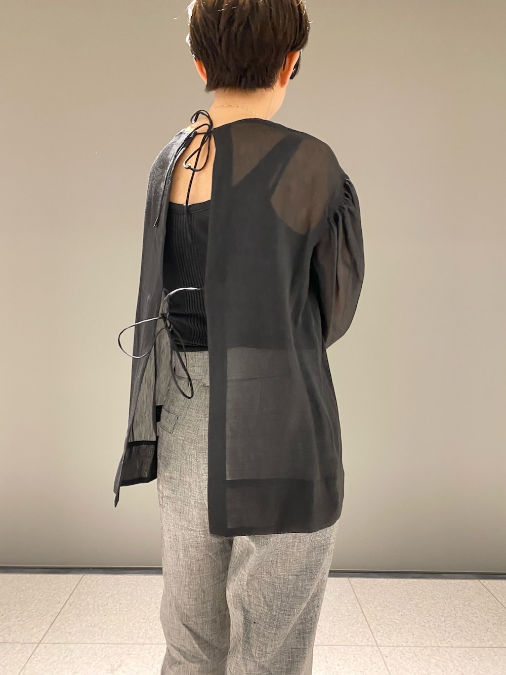 ブラック系のシャツ/ブラウス、ブラック系のタンクトップ、グレー系のパンツを着用したレディースの春コーディネートの5枚目の写真