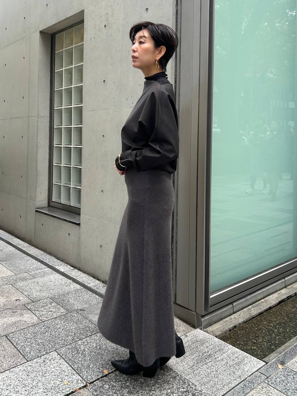ブラック系のその他トップス、ブラック系のノーカラーコート、グレー系のスカートを着用したレディースの秋コーディネートの3枚目の写真