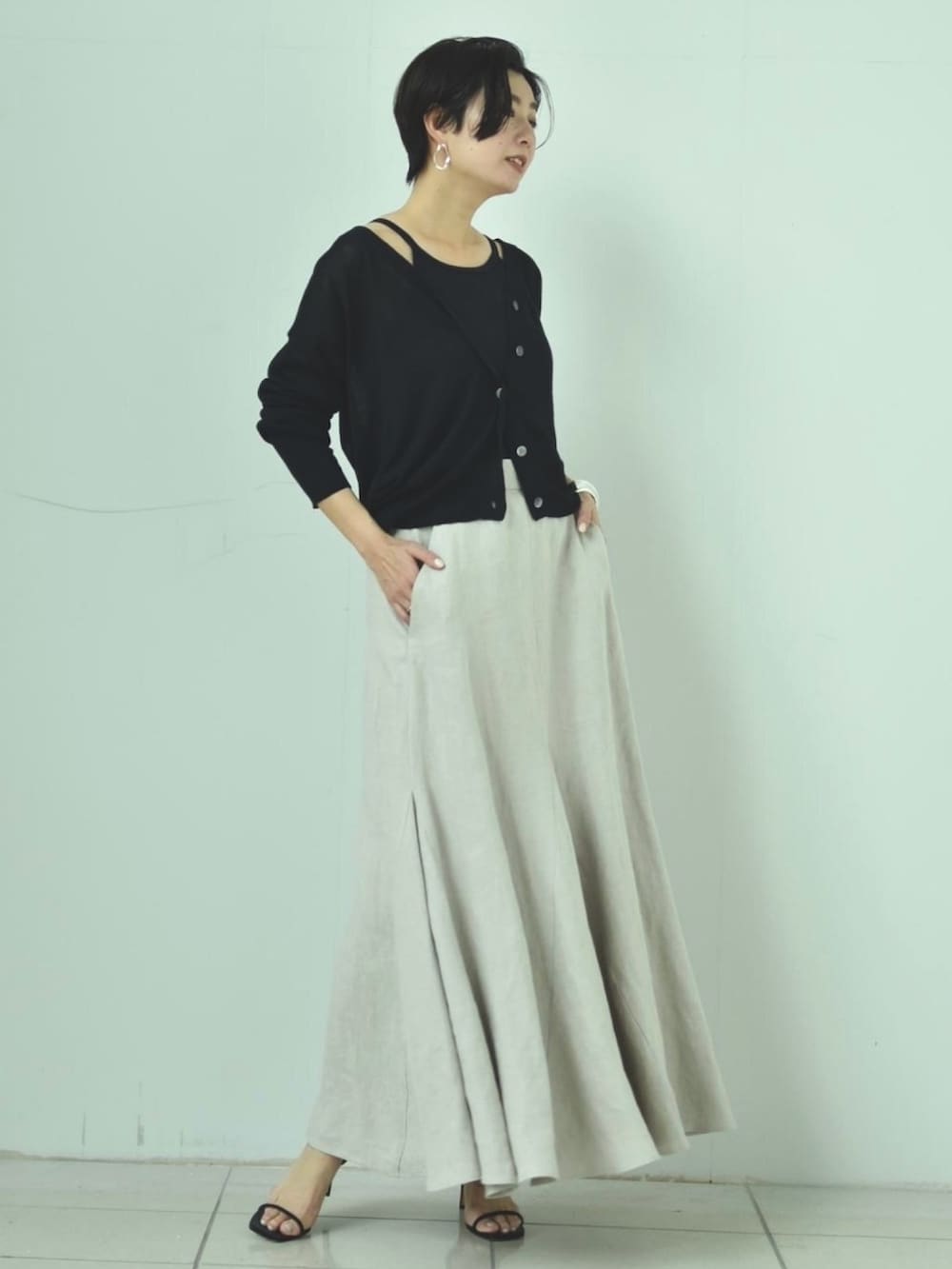 ブラック系のカーディガン/ボレロ、ブラック系のキャミソール、その他のスカートを着用したレディースの春コーディネートの2枚目の写真