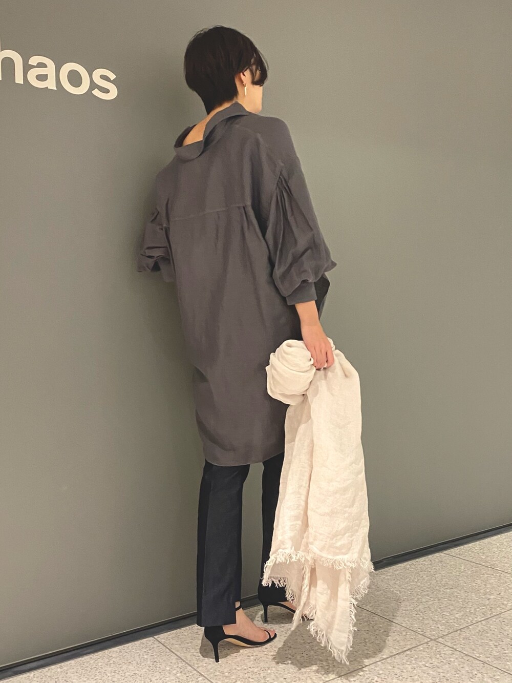 グレー系のシャツ/ブラウス、ブルー系のデニムパンツ、ブラック系のサンダルを着用したレディースの春コーディネートの5枚目の写真