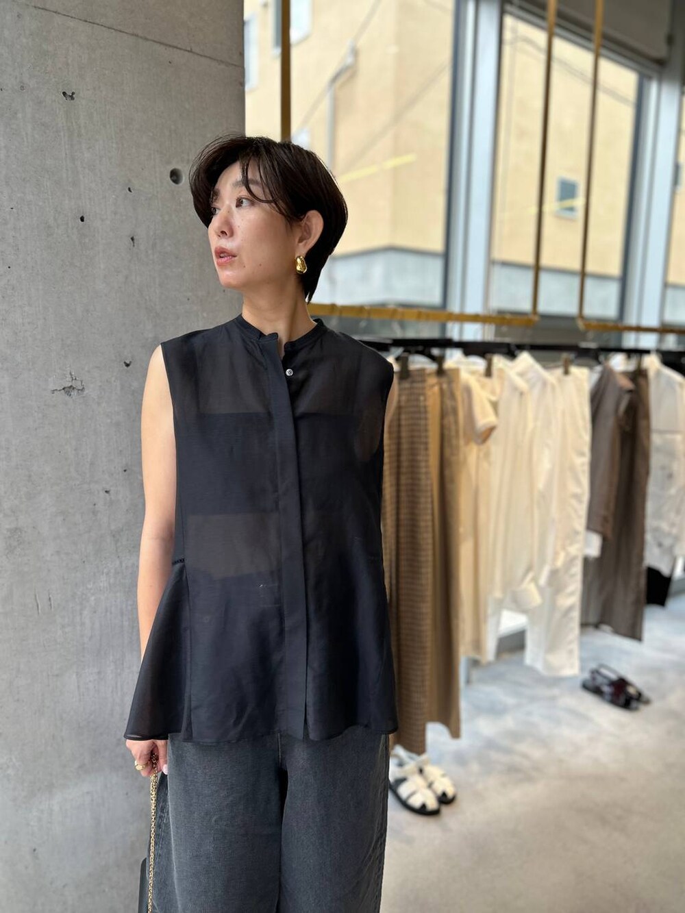 ブラック系のキャミソール、ブラック系のサンダル、ブラック系のデニムパンツを着用したレディースの夏コーディネートの6枚目の写真