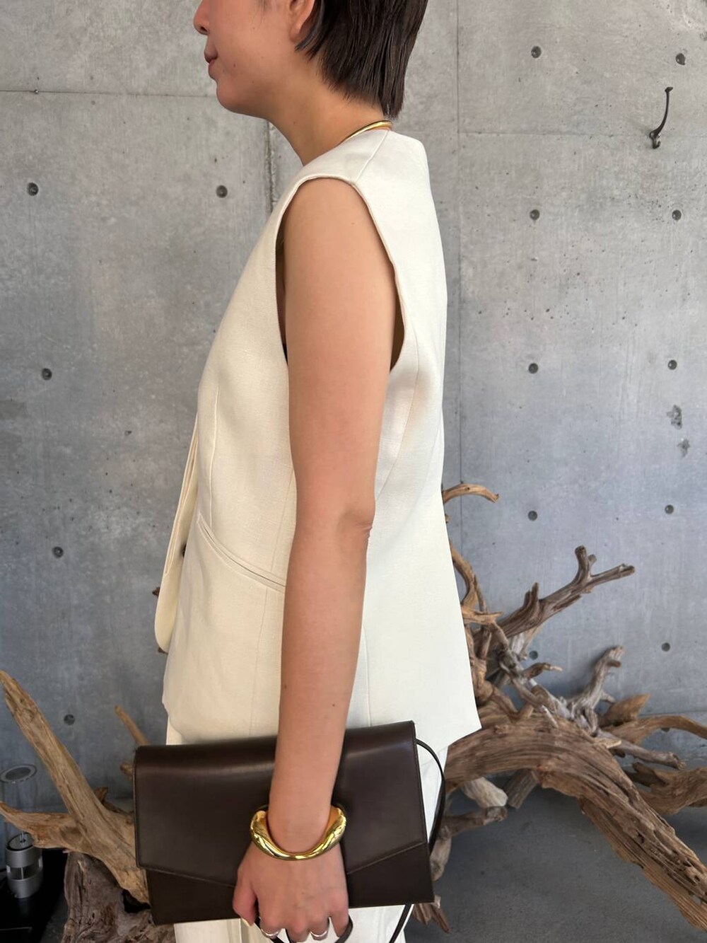 ブルー系のキャミソール、ベージュ系のサンダル、ホワイト系のスラックスを着用したレディースの夏コーディネートの5枚目の写真