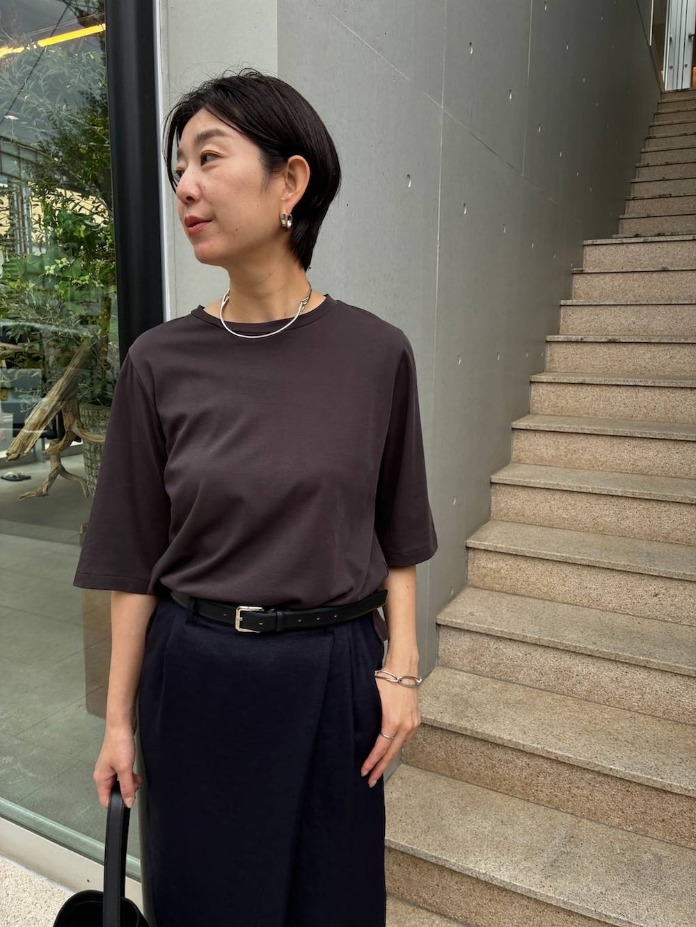 ブルー系のスカート、ブラック系のサンダル、ブラウン系のTシャツ/カットソーを着用したレディースの春コーディネートの5枚目の写真