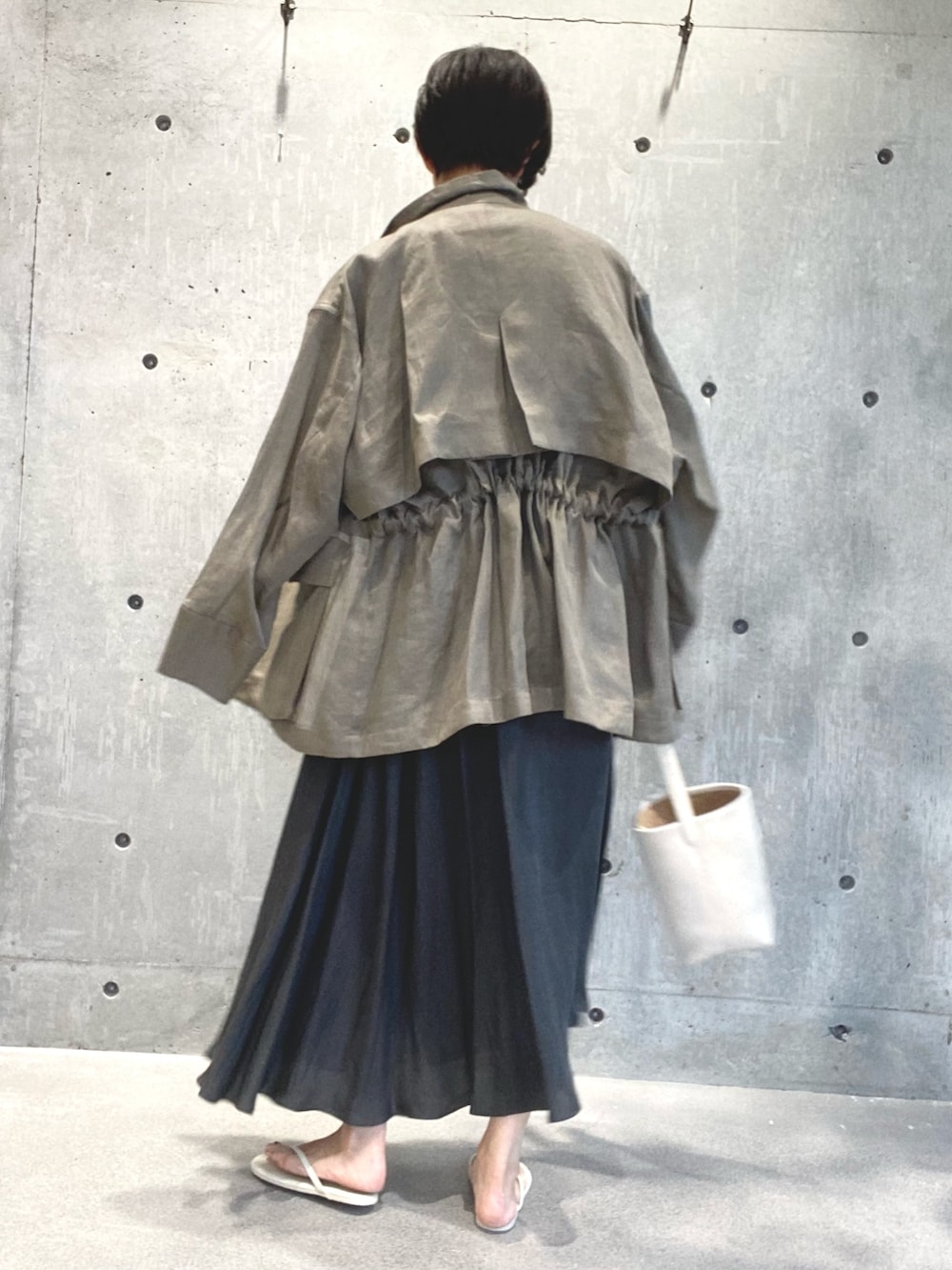 ベージュ系のジャケット/アウター、グレー系のワンピース/ドレス、ベージュ系のサンダルを着用したレディースの夏コーディネートの3枚目の写真