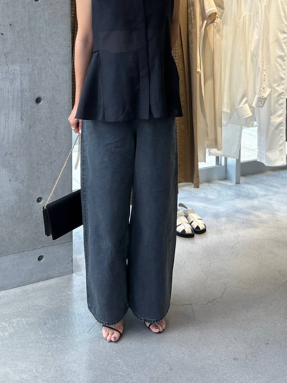 ブラック系のキャミソール、ブラック系のサンダル、ブラック系のデニムパンツを着用したレディースの夏コーディネートの9枚目の写真