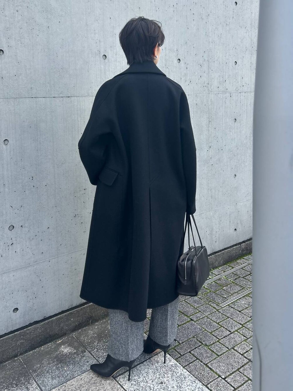 ホワイト系のその他トップス、ブラック系のチェスターコート、グレー系のスラックスを着用したレディースの秋コーディネートの4枚目の写真