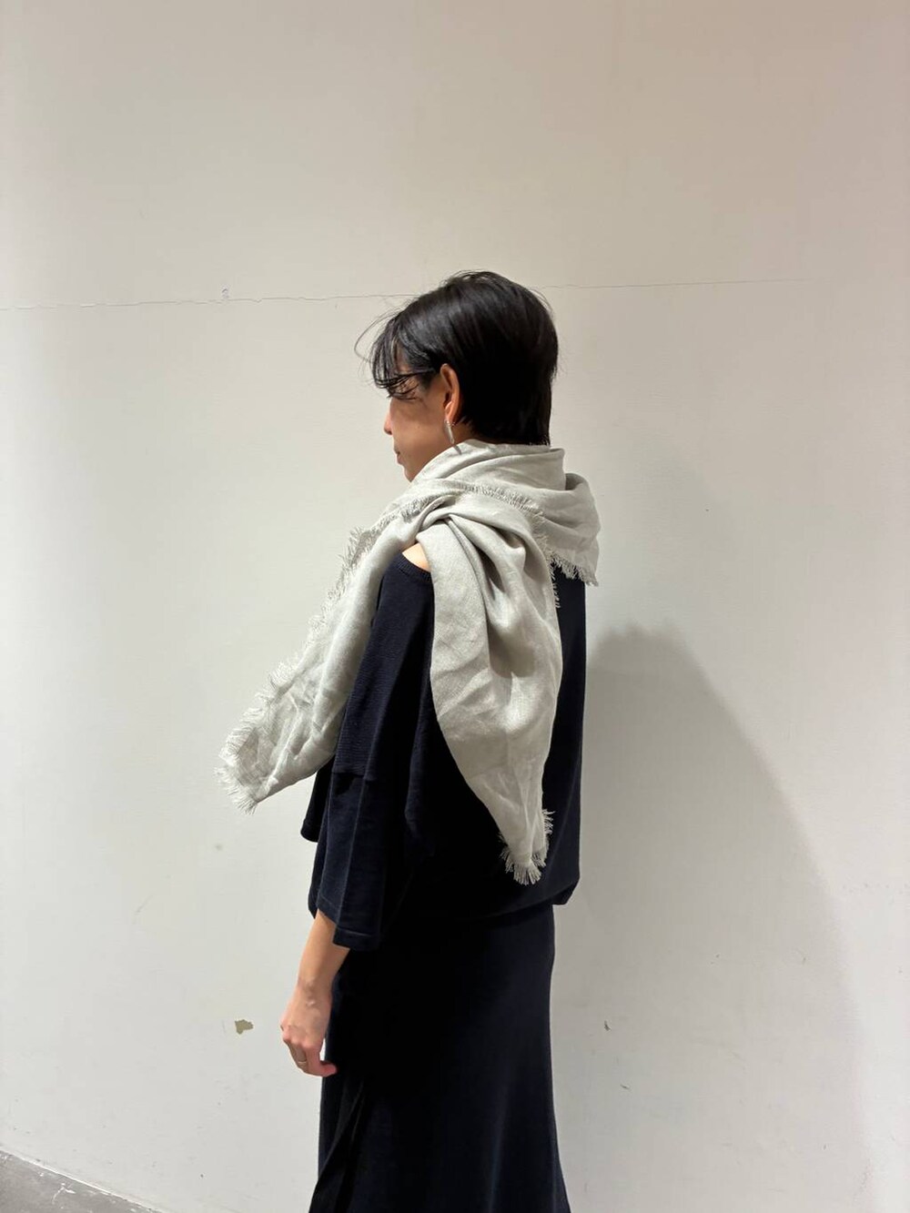 ブルー系のニット/セーター、ブルー系のスカート、グレー系のストール/ショールを着用したレディースの春コーディネートの5枚目の写真