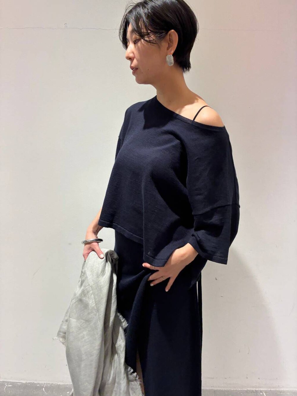 ブルー系のニット/セーター、ブルー系のスカート、グレー系のストール/ショールを着用したレディースの春コーディネートの4枚目の写真