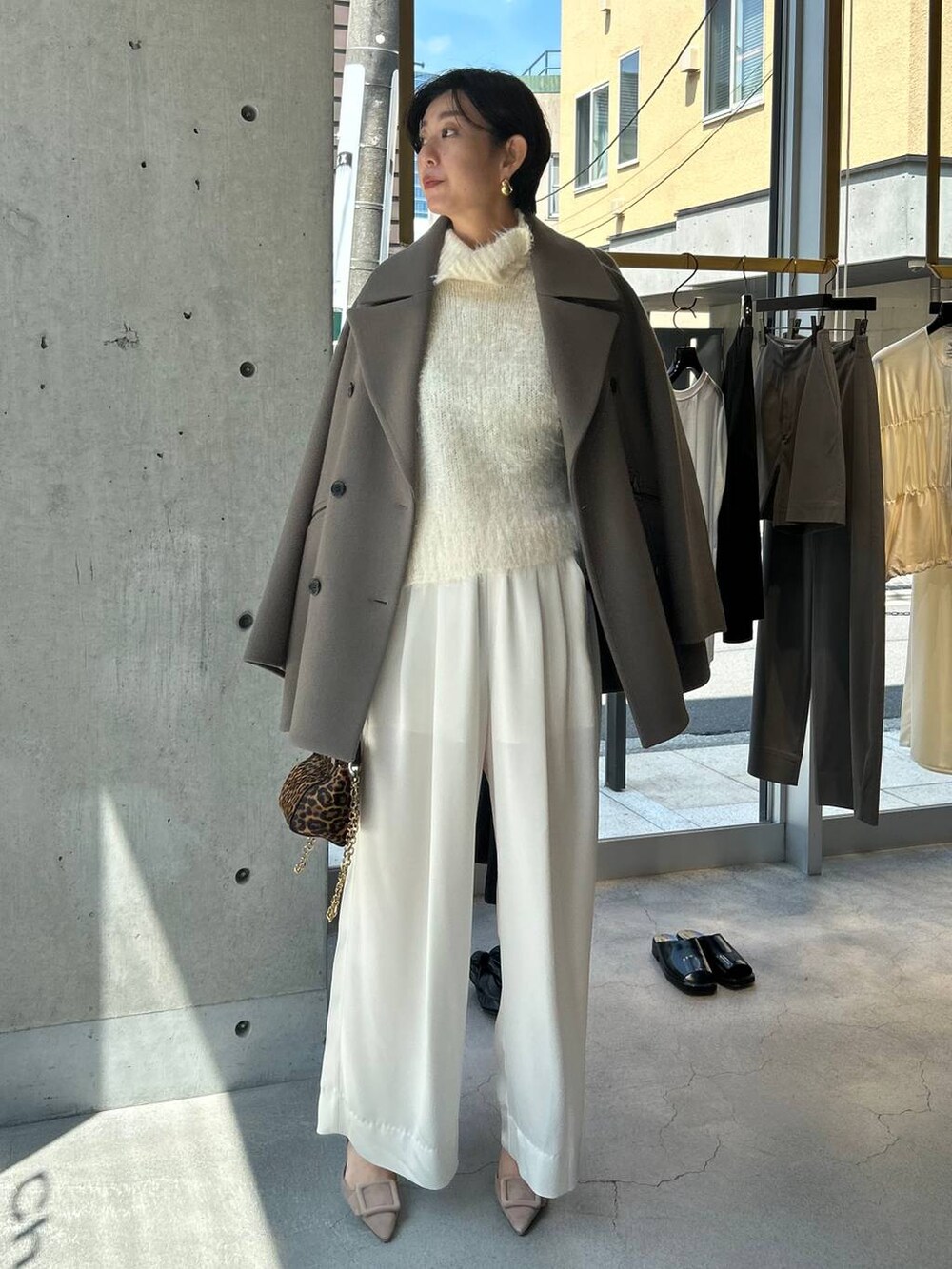 ホワイト系のニット/セーター、ホワイト系のその他パンツ、ブラウン系のピーコートを着用したレディースの秋コーディネートの8枚目の写真