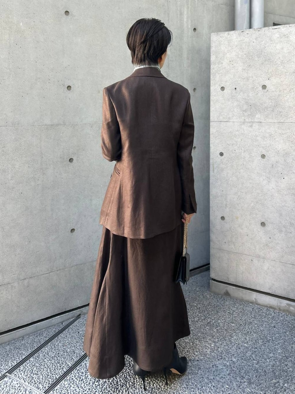 ブルー系のニット/セーター、ブラウン系のテーラードジャケット、ブラウン系のスカートを着用したレディースの冬コーディネートの4枚目の写真