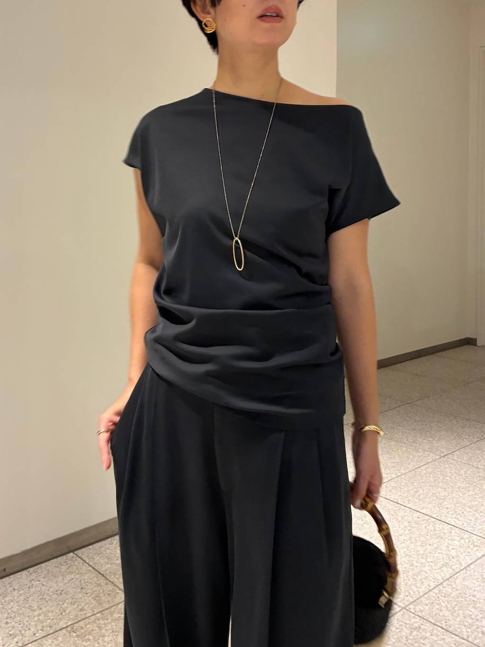 グレー系のその他パンツ、グレー系のTシャツ/カットソー、ベージュ系のハンドバッグを着用したレディースの夏コーディネートの4枚目の写真