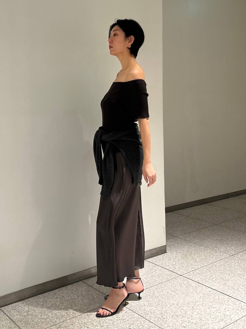 グリーン系のカーディガン/ボレロ、グリーン系のスカート、ブラウン系のTシャツ/カットソーを着用したレディースの春コーディネートの2枚目の写真