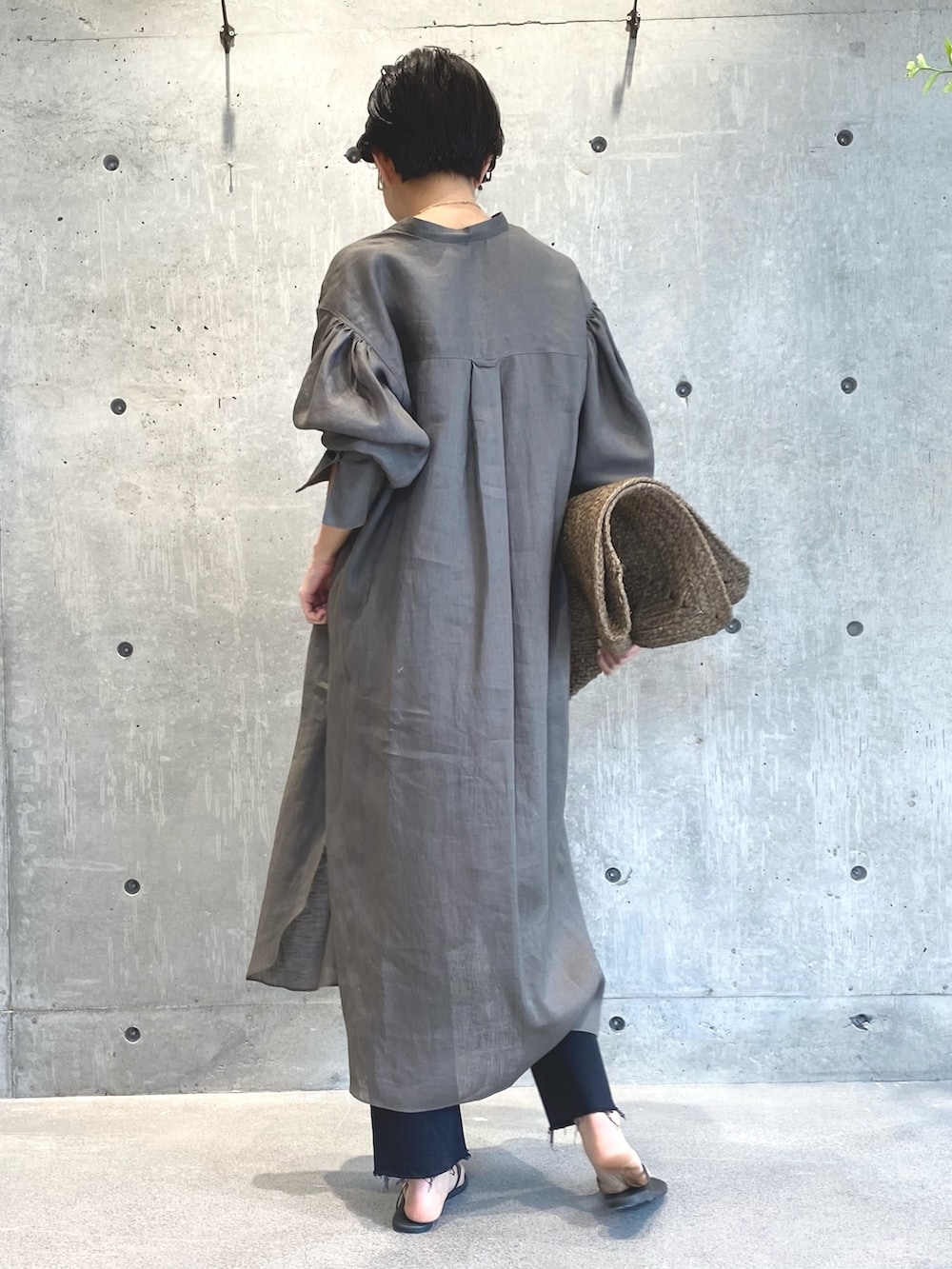 グリーン系のワンピース、ブラック系のデニムパンツ、ブラック系のサンダルを着用したレディースの夏コーディネートの4枚目の写真