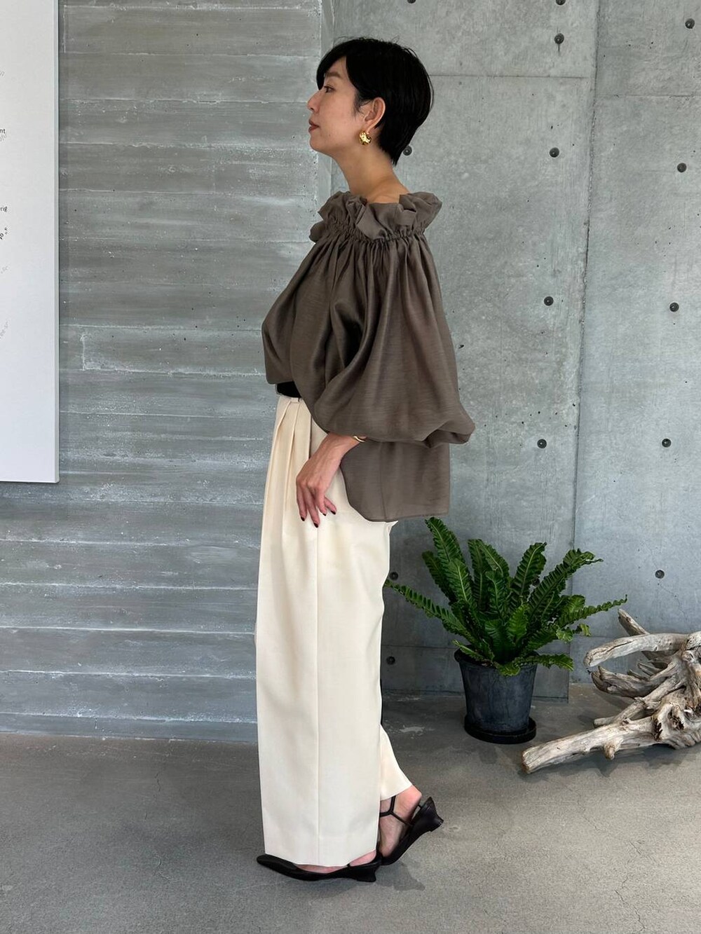 ホワイト系のスラックス、ブラウン系のトレンチコート、ブラウン系のその他アウターを着用したレディースの秋コーディネートの4枚目の写真