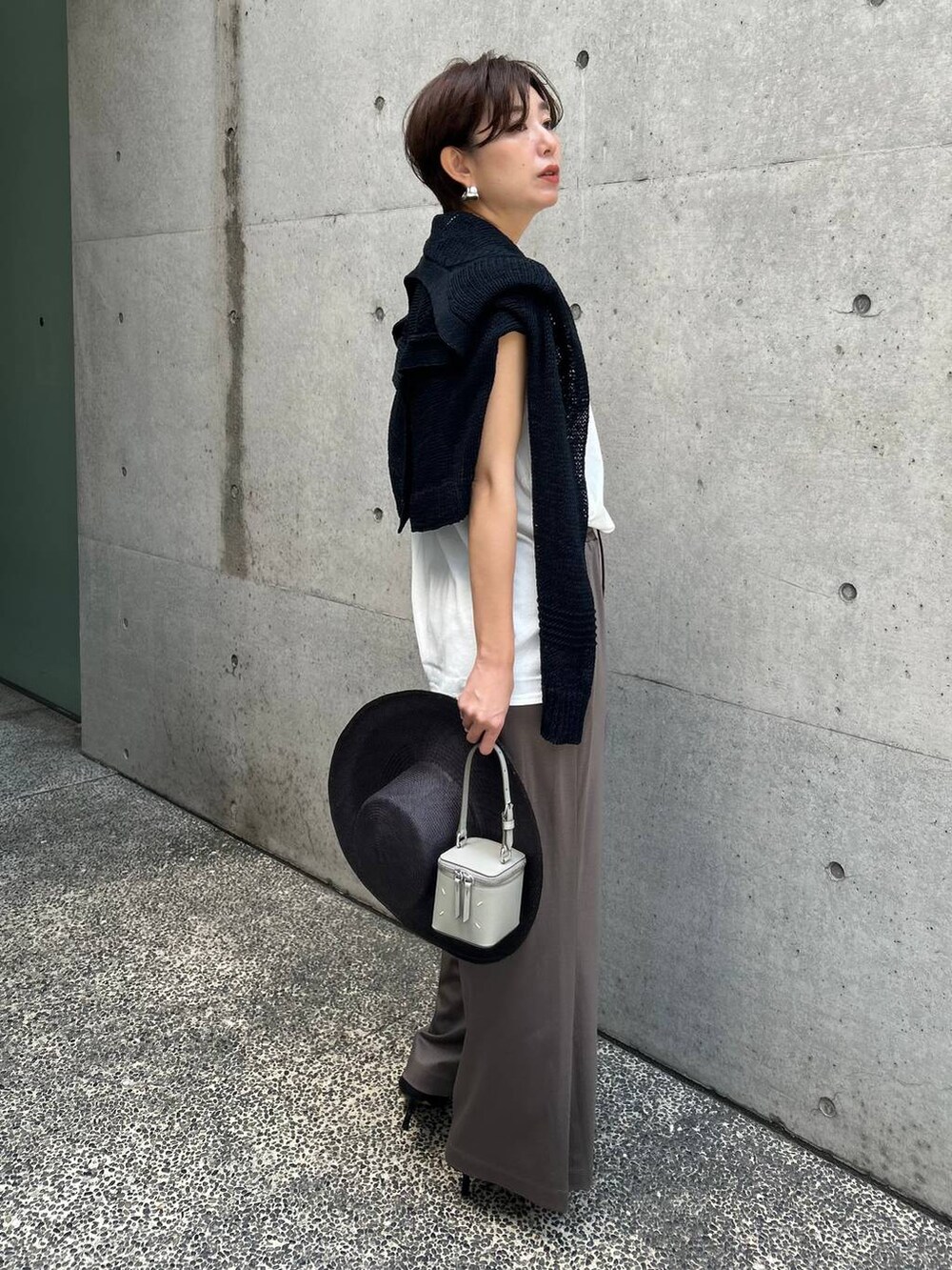 ホワイト系のTシャツ/カットソー、ブラック系のアンサンブル、ブラック系のサンダルを着用したレディースの春コーディネートの3枚目の写真