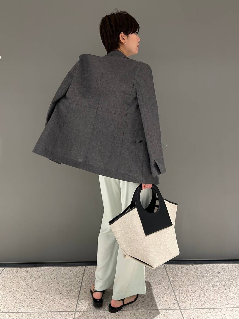 グリーン系のその他パンツ、ホワイト系のニット/セーター、ブラック系のテーラードジャケットを着用したレディースの春コーディネートの6枚目の写真