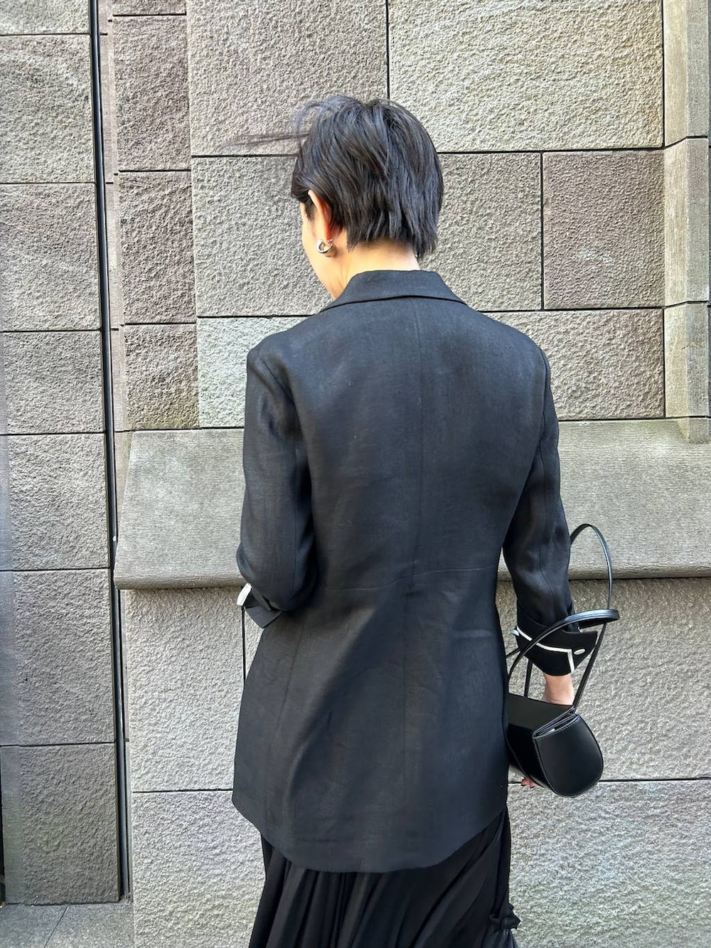 ベージュ系のタンクトップ、ブラック系のサンダル、ブラック系のテーラードジャケットを着用したレディースの冬コーディネートの7枚目の写真