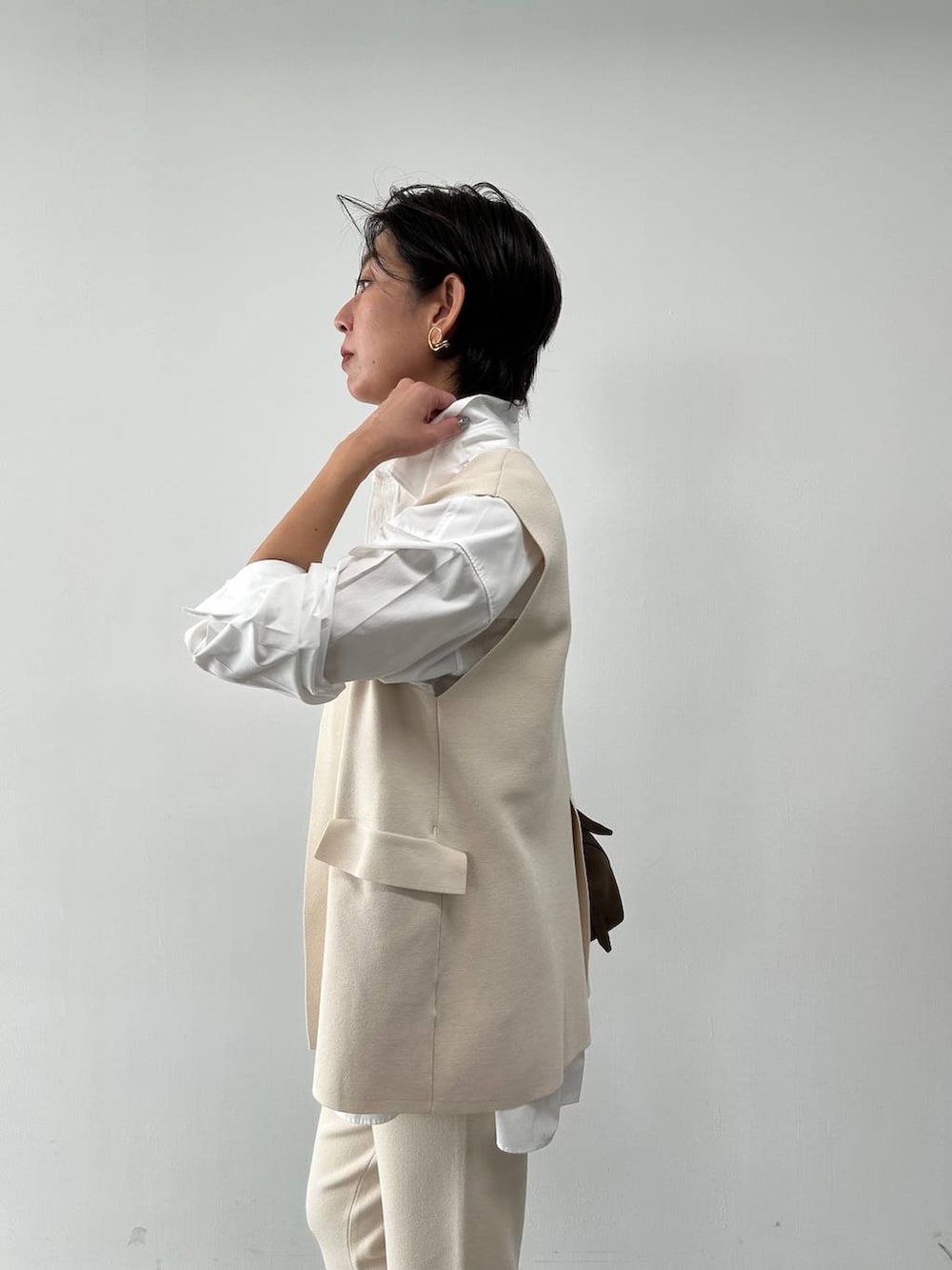 ホワイト系のシャツ/ブラウス、ベージュ系のベスト、ベージュ系のブルゾンを着用したレディースの冬コーディネートの8枚目の写真