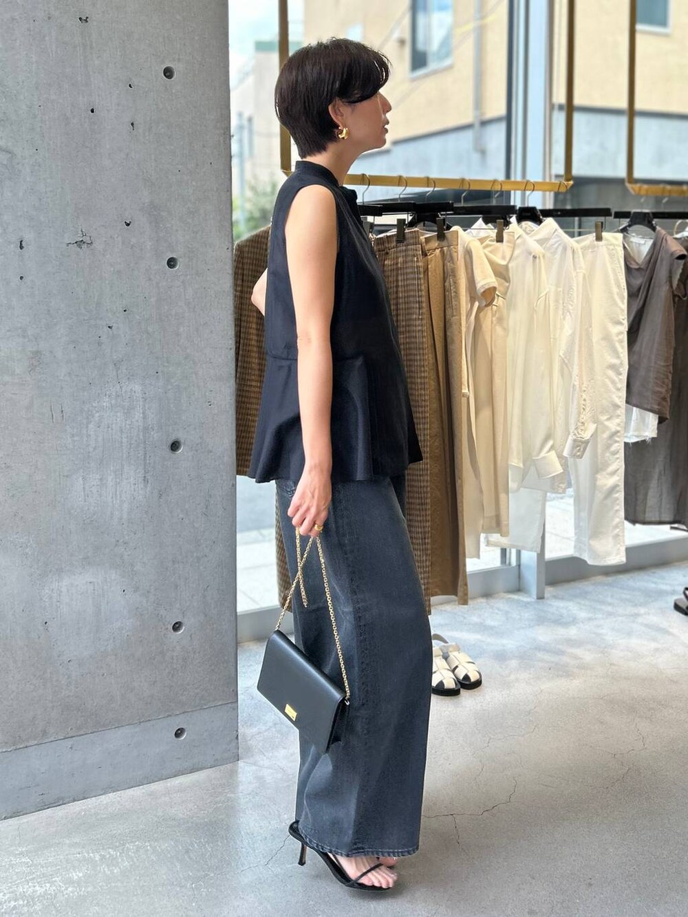 ブラック系のキャミソール、ブラック系のサンダル、ブラック系のデニムパンツを着用したレディースの夏コーディネートの3枚目の写真