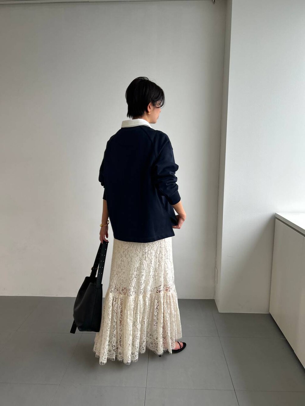 ホワイト系のスカート、ベージュ系のトレンチコートを着用したレディースの冬コーディネートの6枚目の写真