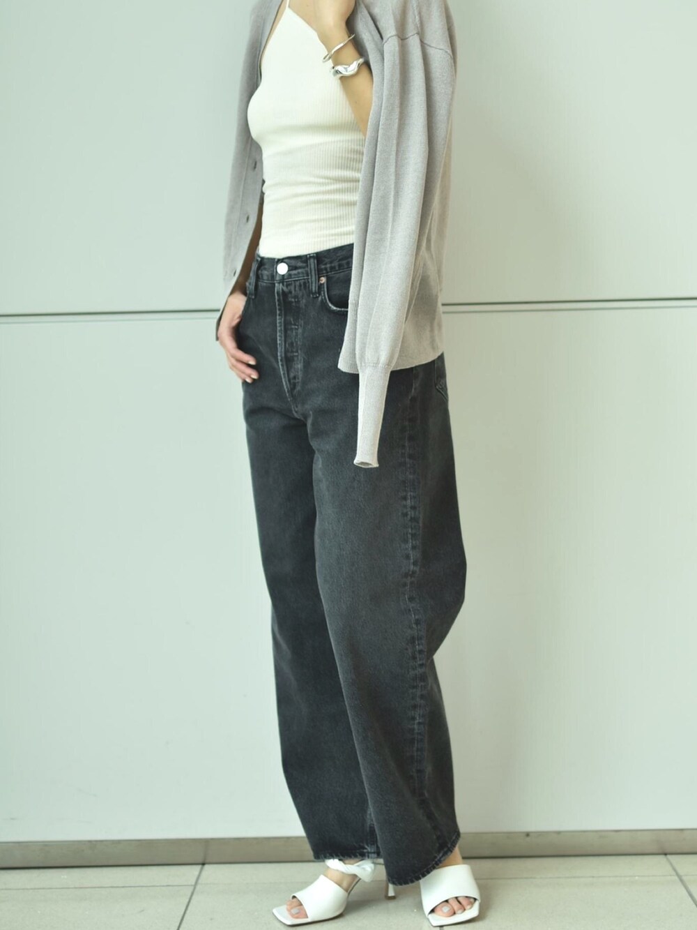 グレー系のカーディガン/ボレロ、ホワイト系のタンクトップ、グレー系のデニムパンツを着用したレディースの春コーディネートの5枚目の写真