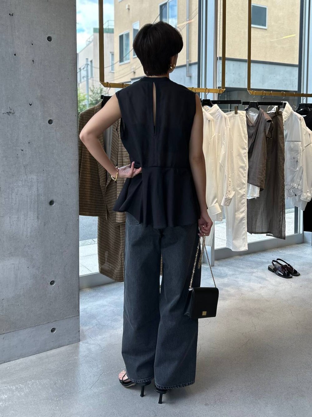 ブラック系のキャミソール、ブラック系のサンダル、ブラック系のデニムパンツを着用したレディースの夏コーディネートの5枚目の写真