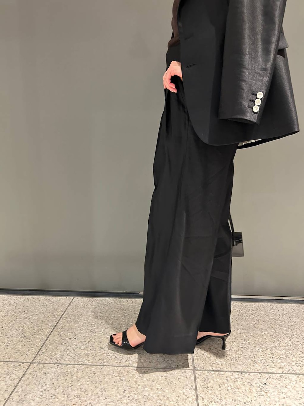 ブラック系のスラックス、ブラック系のテーラードジャケットを着用したレディースの春コーディネートの7枚目の写真