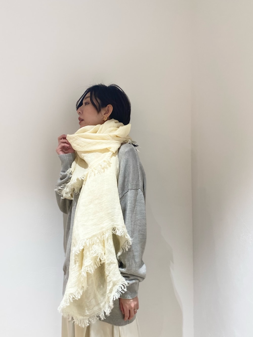 グレー系のカーディガン/ボレロ、ベージュ系のスカート、ベージュ系のストール/ショールを着用したレディースの冬コーディネートの4枚目の写真