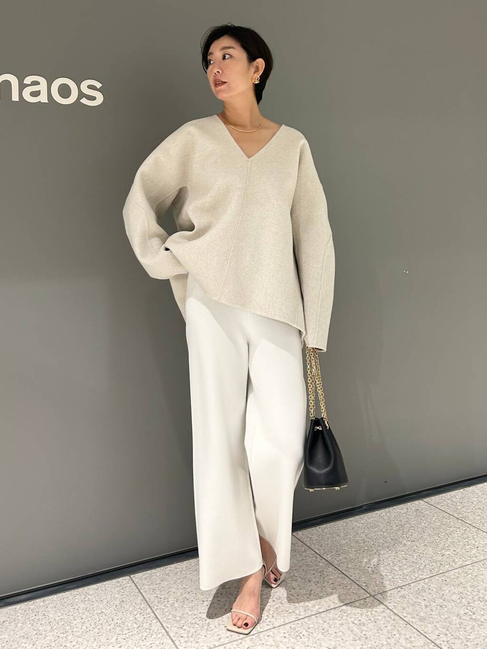 ホワイト系のその他パンツ、ホワイト系のその他トップス、ベージュ系のサンダルを着用したレディースの秋コーディネートの2枚目の写真