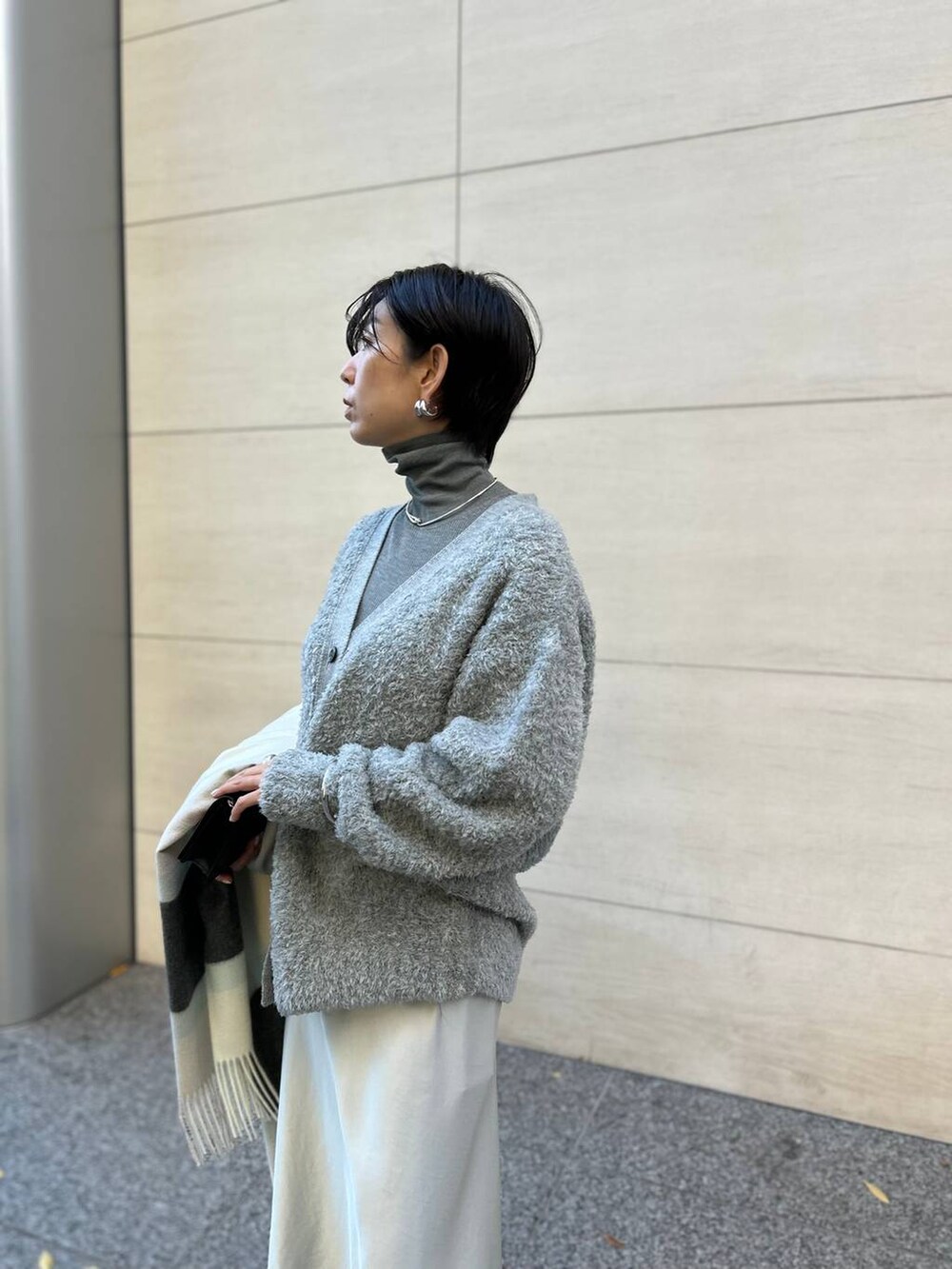 グレー系のカーディガン/ボレロ、グレー系のニット/セーター、ブラウン系のノーカラーコートを着用したレディースの秋コーディネートの5枚目の写真