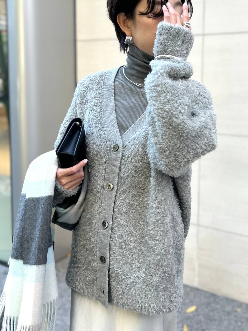 グレー系のカーディガン/ボレロ、グレー系のニット/セーター、ブラウン系のノーカラーコートを着用したレディースの秋コーディネートの4枚目の写真