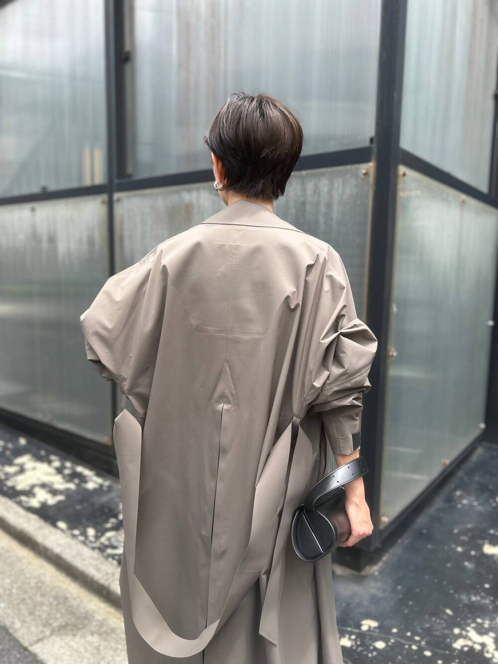 ベージュ系のシャツ/ブラウス、ブラウン系のトレンチコート、ブラック系のサンダルを着用したレディースの夏コーディネートの6枚目の写真