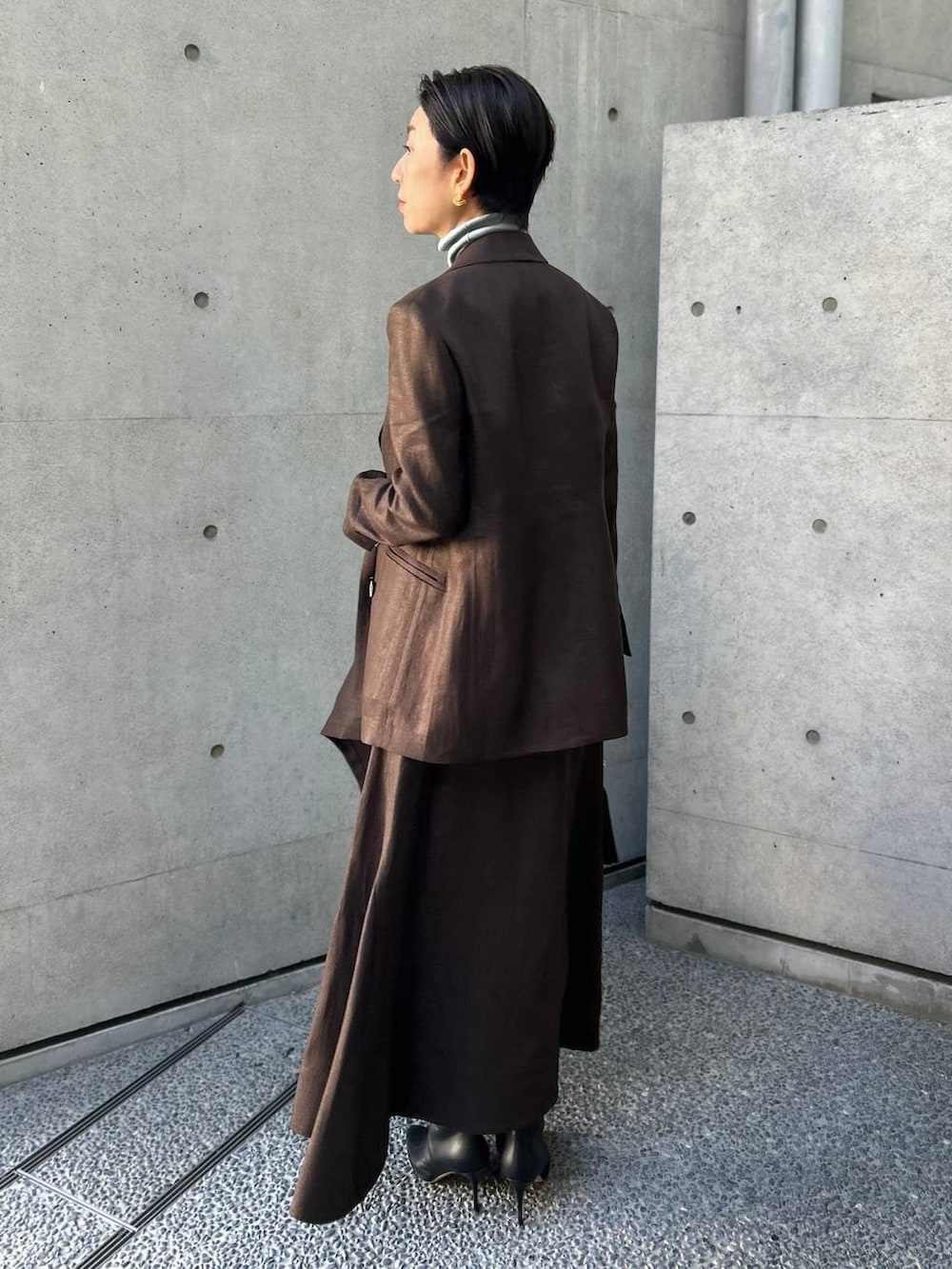 ブルー系のニット/セーター、ブラウン系のテーラードジャケット、ブラウン系のスカートを着用したレディースの冬コーディネートの3枚目の写真