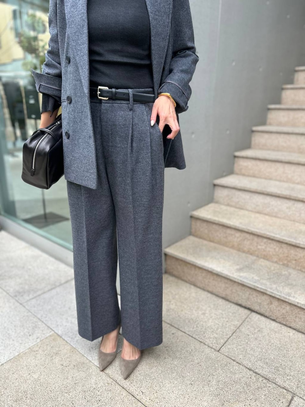 ブラック系のニット/セーター、グレー系のブルゾン、ホワイト系のスラックスを着用したレディースの秋コーディネートの9枚目の写真