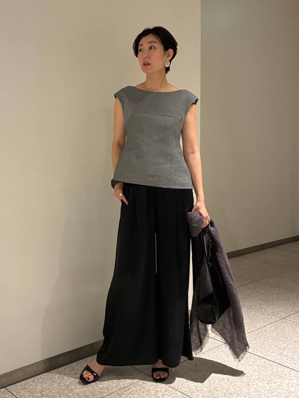 ブラック系のその他パンツ、ホワイト系のその他トップス、ブラウン系のストール/ショールを着用したレディースの春コーディネートの2枚目の写真