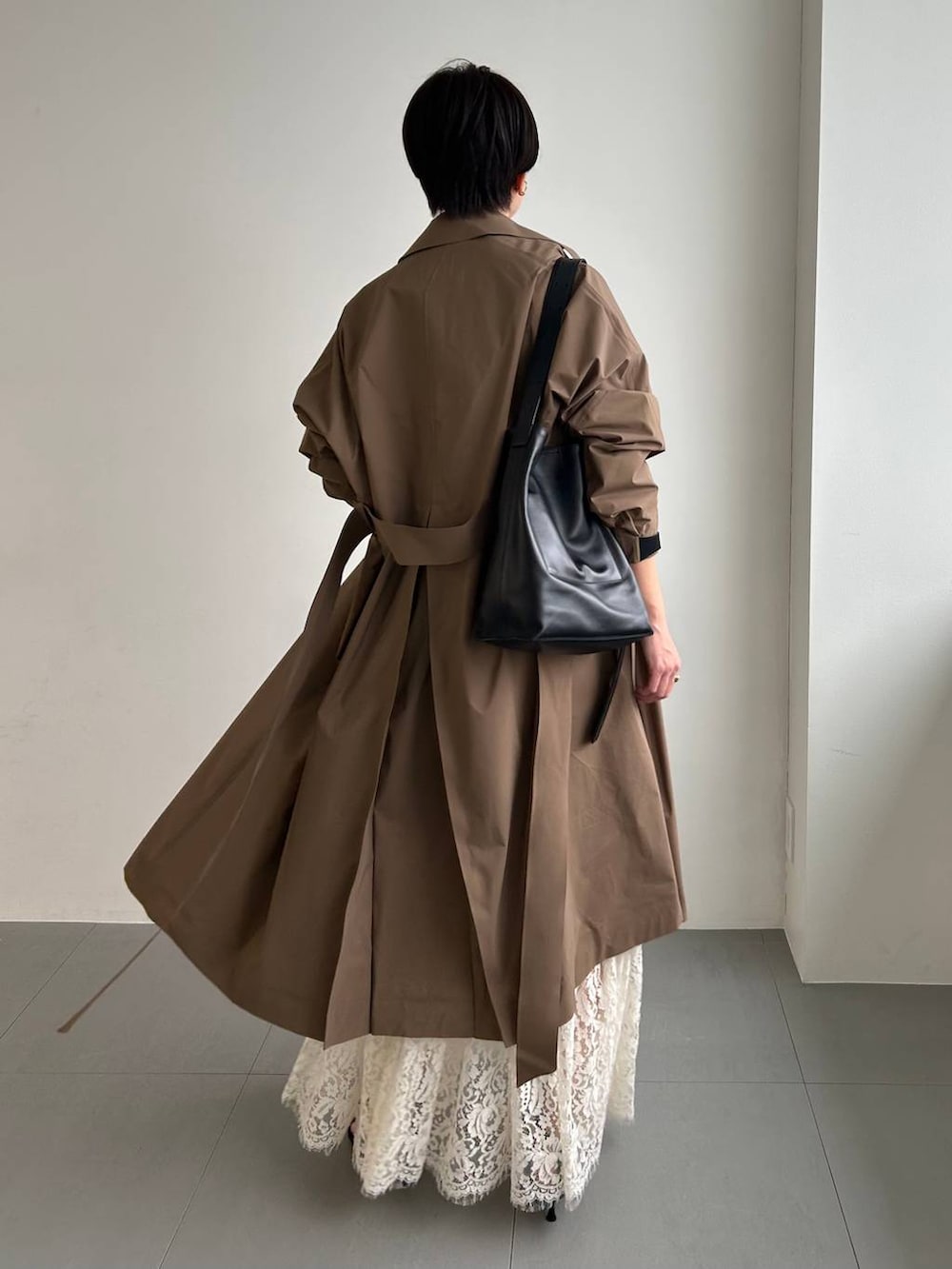 ホワイト系のスカート、ベージュ系のトレンチコートを着用したレディースの冬コーディネートの4枚目の写真