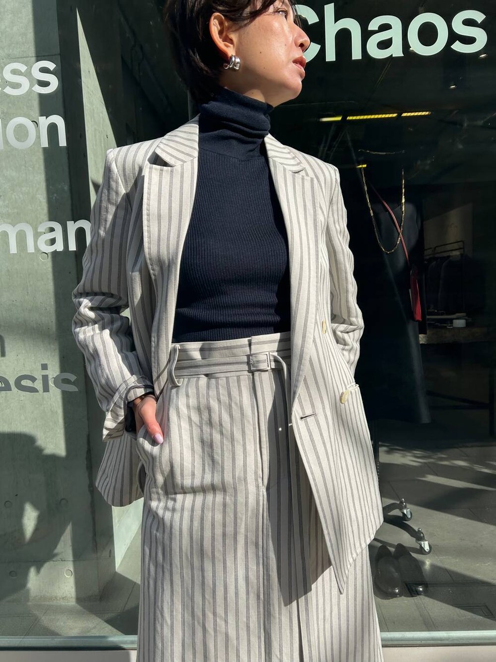 ブルー系のニット/セーター、ホワイト系のテーラードジャケット、ホワイト系のスカートを着用したレディースの冬コーディネートの5枚目の写真