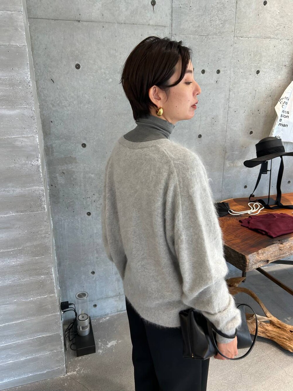 ピンク系のノーカラーコート、グレー系のニット/セーター、ブラック系のベルトを着用したレディースの秋コーディネートの9枚目の写真