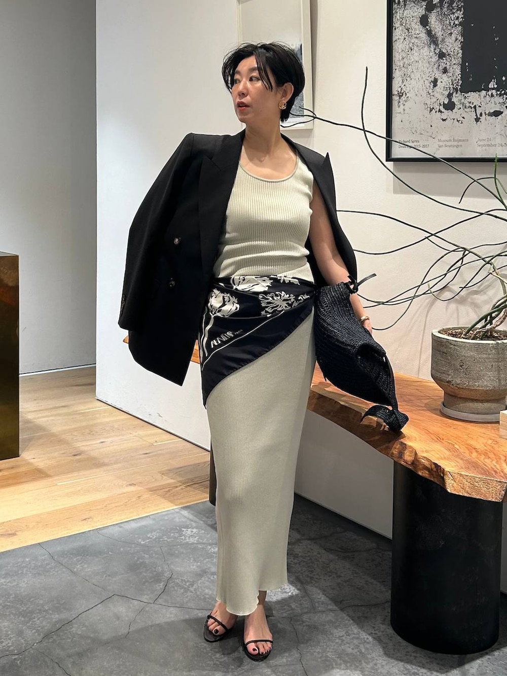 グレー系のタンクトップ、ブラック系のブルゾン、グレー系のスカートを着用したレディースの春コーディネートの6枚目の写真