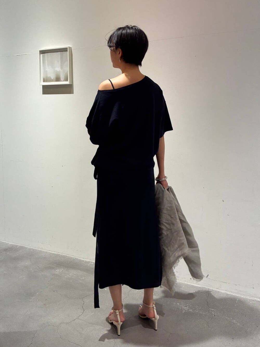 ブルー系のニット/セーター、ブルー系のスカート、グレー系のストール/ショールを着用したレディースの春コーディネートの3枚目の写真