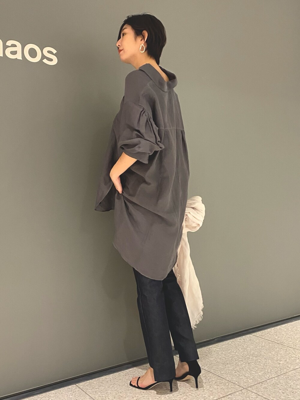 グレー系のシャツ/ブラウス、ブルー系のデニムパンツ、ブラック系のサンダルを着用したレディースの春コーディネートの3枚目の写真