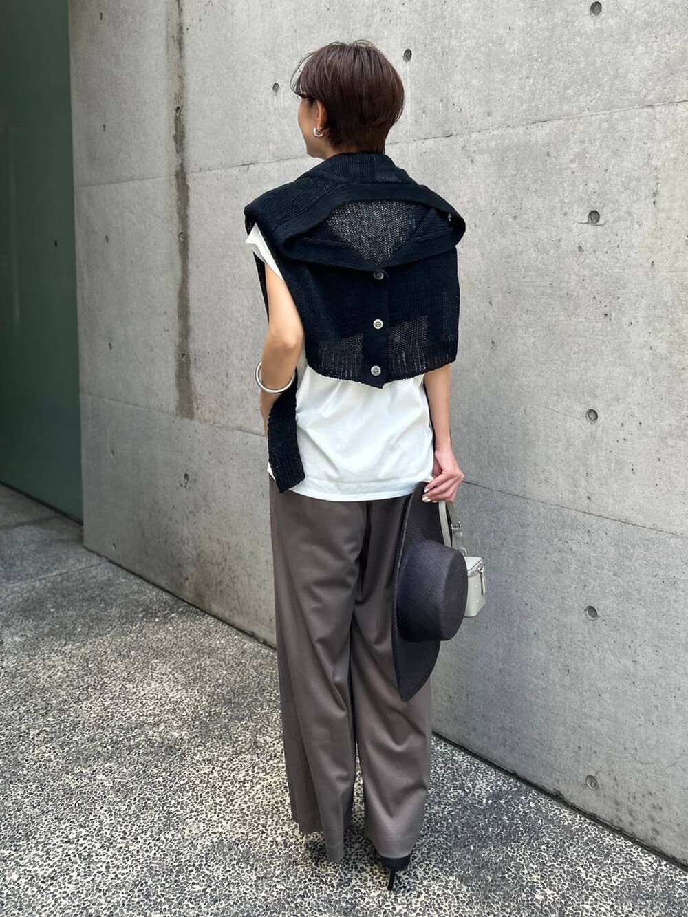 ホワイト系のTシャツ/カットソー、ブラック系のアンサンブル、ブラック系のサンダルを着用したレディースの春コーディネートの4枚目の写真