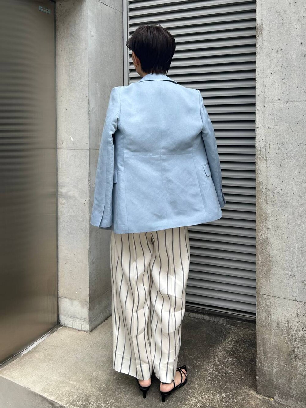 ホワイト系のスラックス、ブルー系のTシャツ/カットソー、ブルー系のテーラードジャケットを着用したレディースの春コーディネートの4枚目の写真