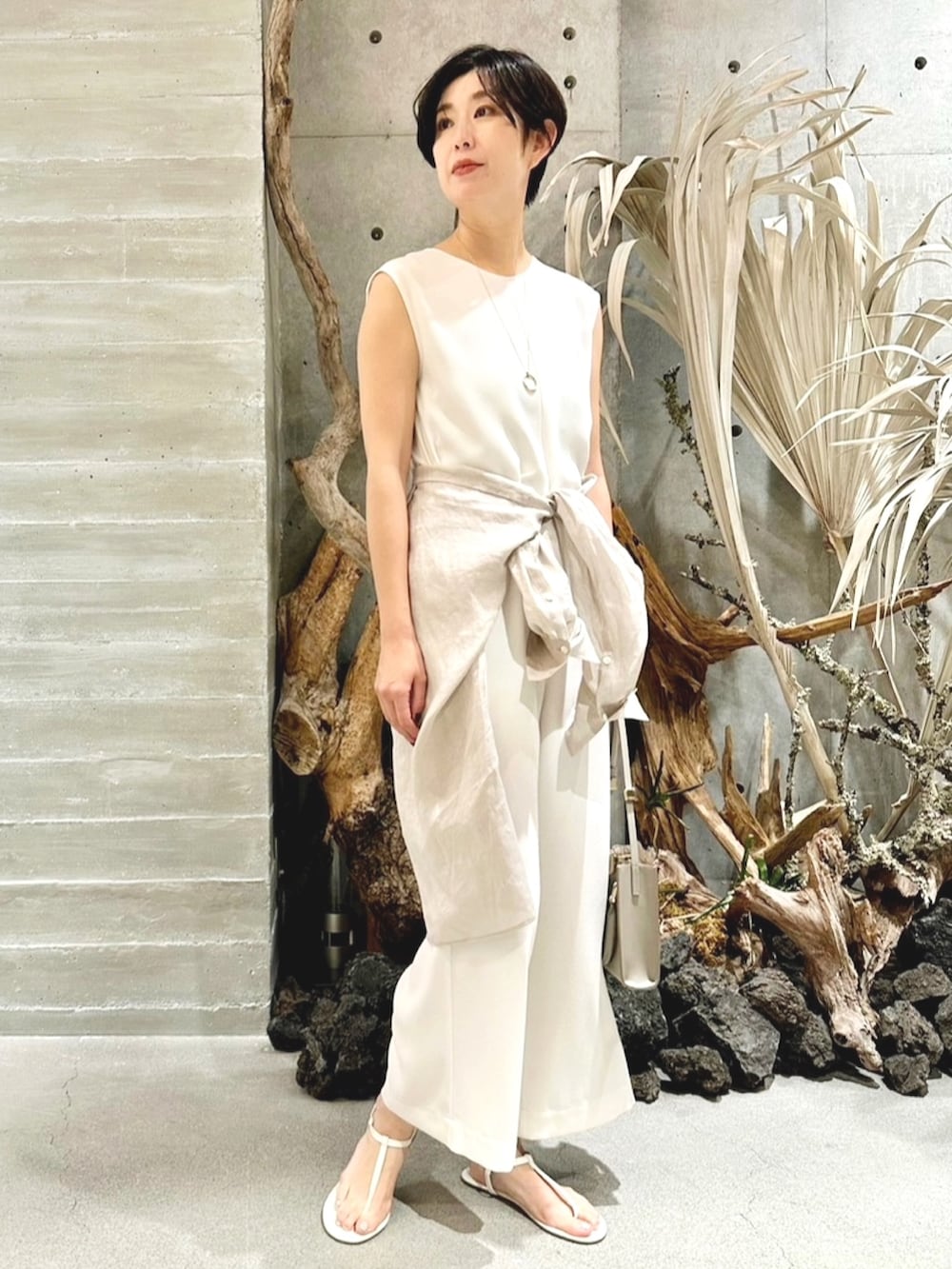 ベージュ系のシャツ/ブラウス、ベージュ系のサロペット/オーバーオール、ベージュ系のバッグを着用したレディースの春コーディネートの2枚目の写真