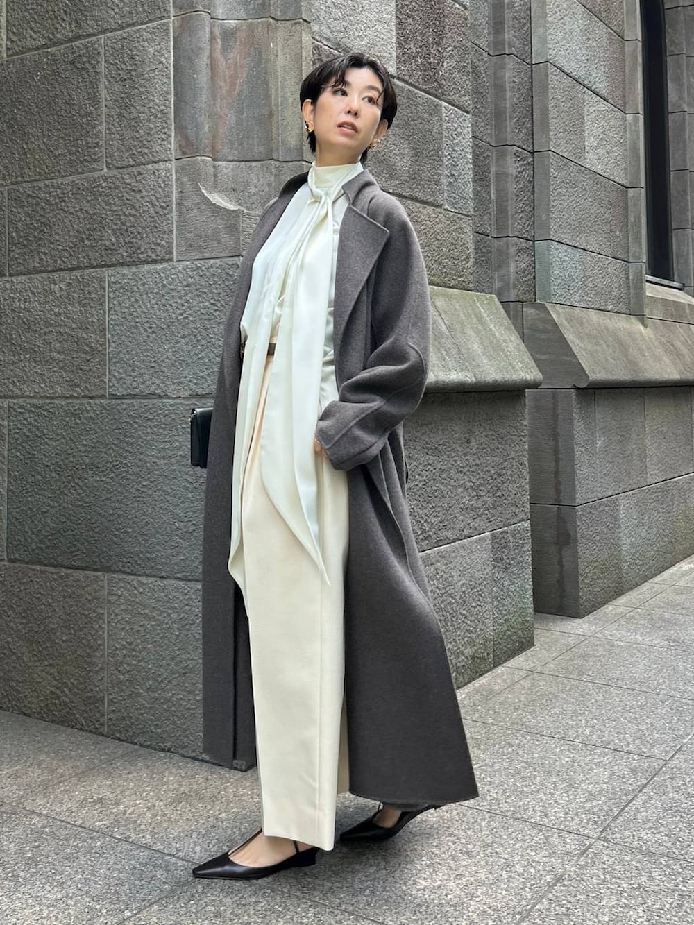 ブラウン系のノーカラーコート、ホワイト系のスラックス、ホワイト系のシャツ/ブラウスを着用したレディースの秋コーディネートの3枚目の写真