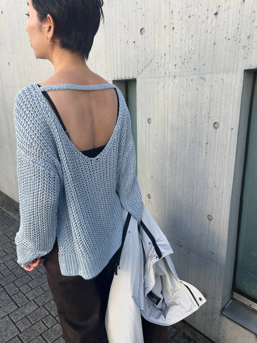 ブルー系のニット/セーター、ホワイト系のその他トップス、グレー系のナイロンジャケットを着用したレディースの冬コーディネートの7枚目の写真