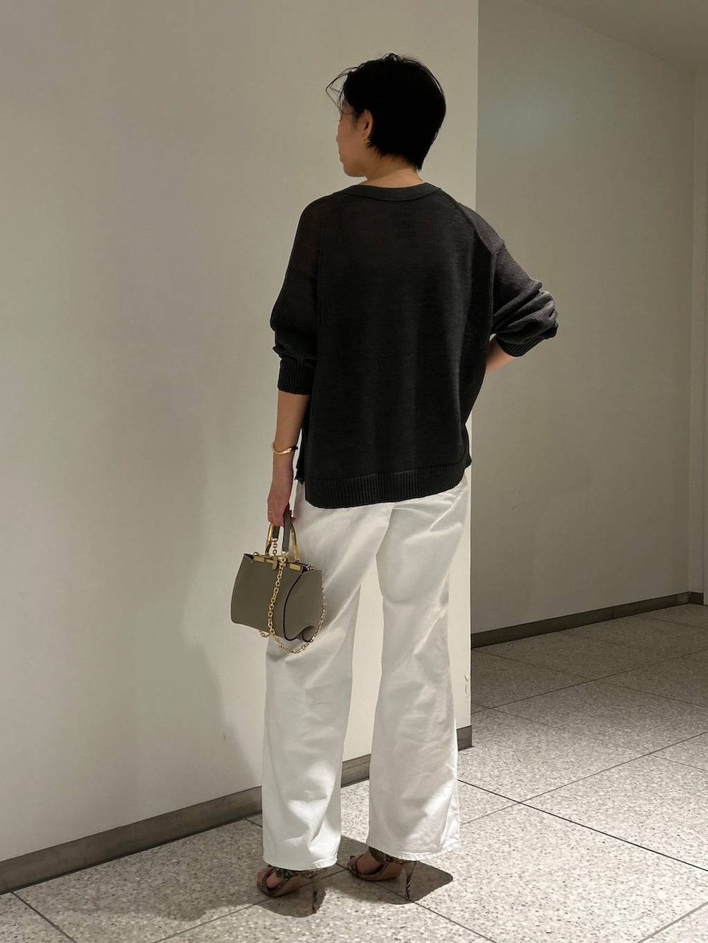 グリーン系のカーディガン/ボレロ、ホワイト系のデニムパンツ、グレー系のナイロンジャケットを着用したレディースの春コーディネートの4枚目の写真