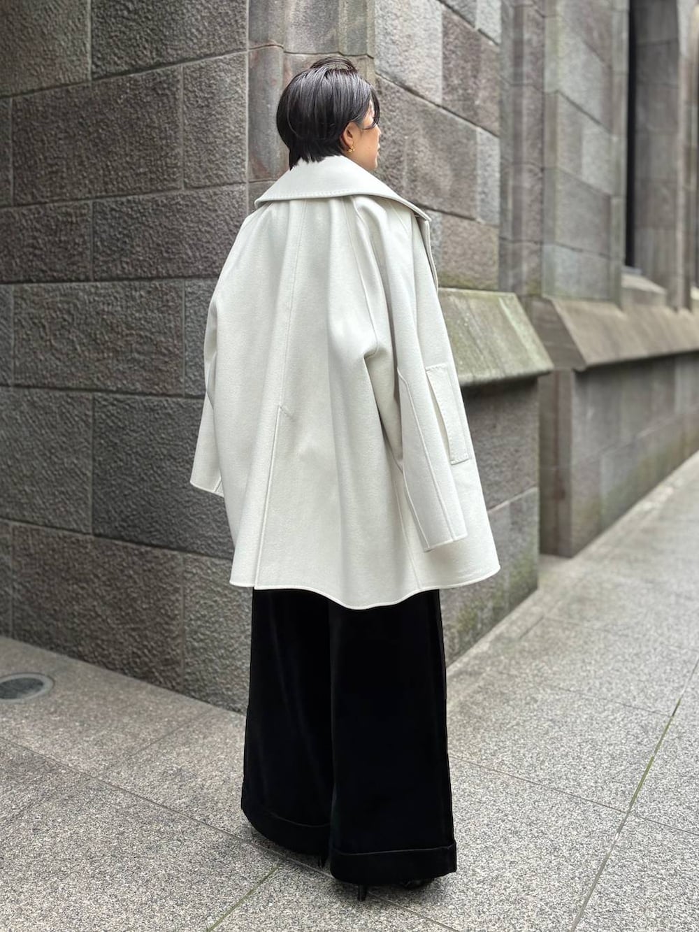 グレー系のニット/セーター、ホワイト系のその他アウター、グレー系のストール/ショールを着用したレディースの秋コーディネートの4枚目の写真