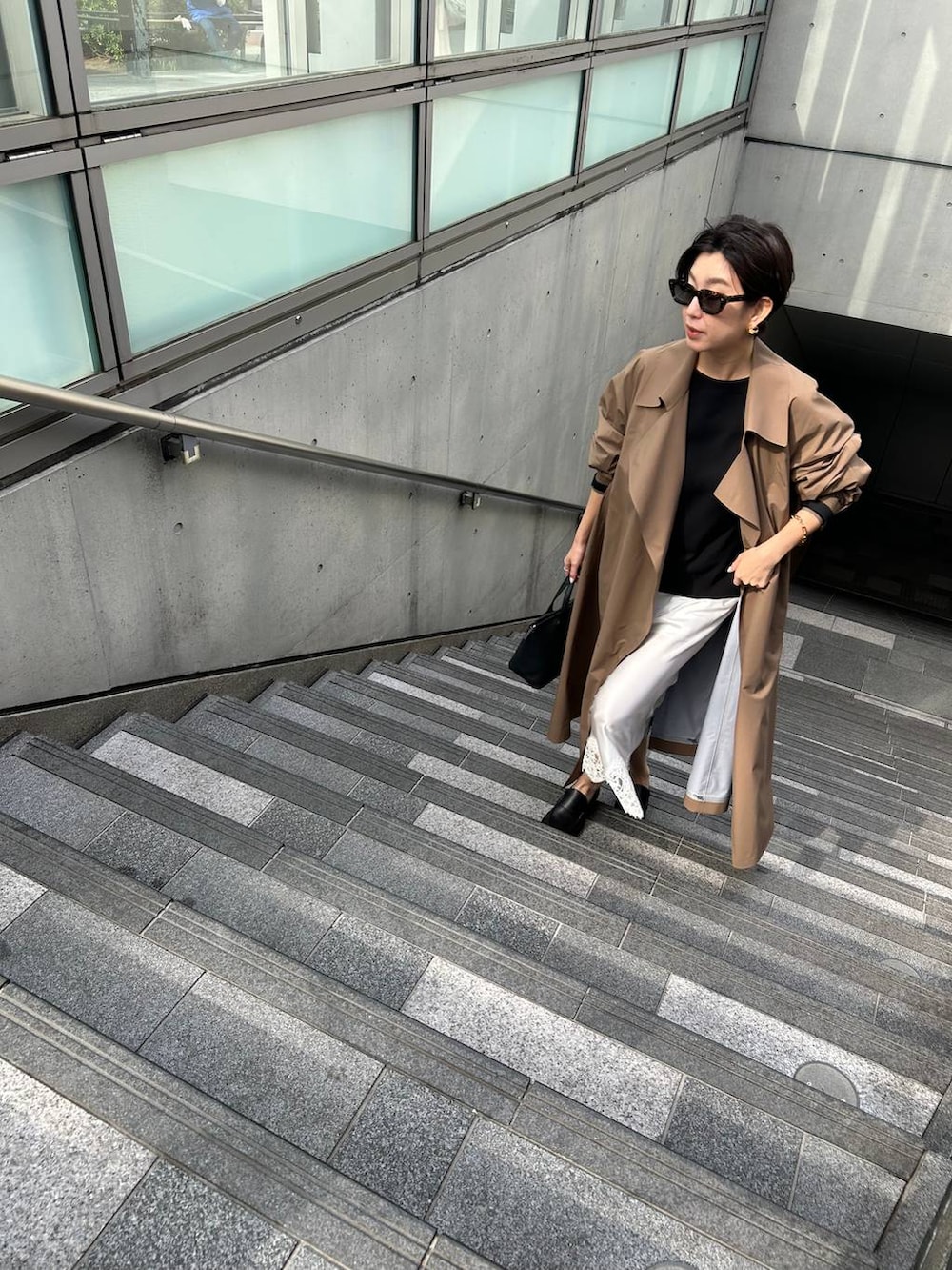 ブラック系のニット/セーター、ベージュ系のトレンチコートを着用したレディースの冬コーディネートの8枚目の写真